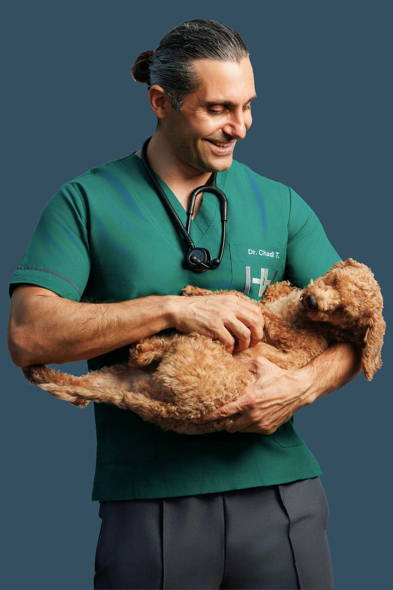 Dr. Chadi holding a brown dog